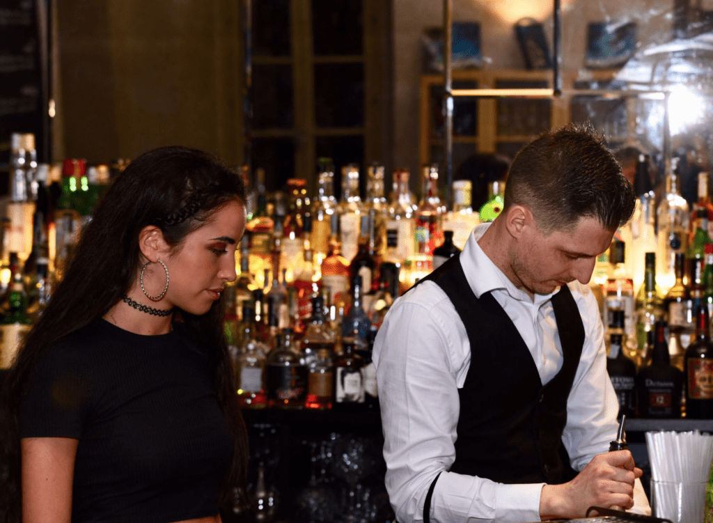 ragazza di fianco a un bartender